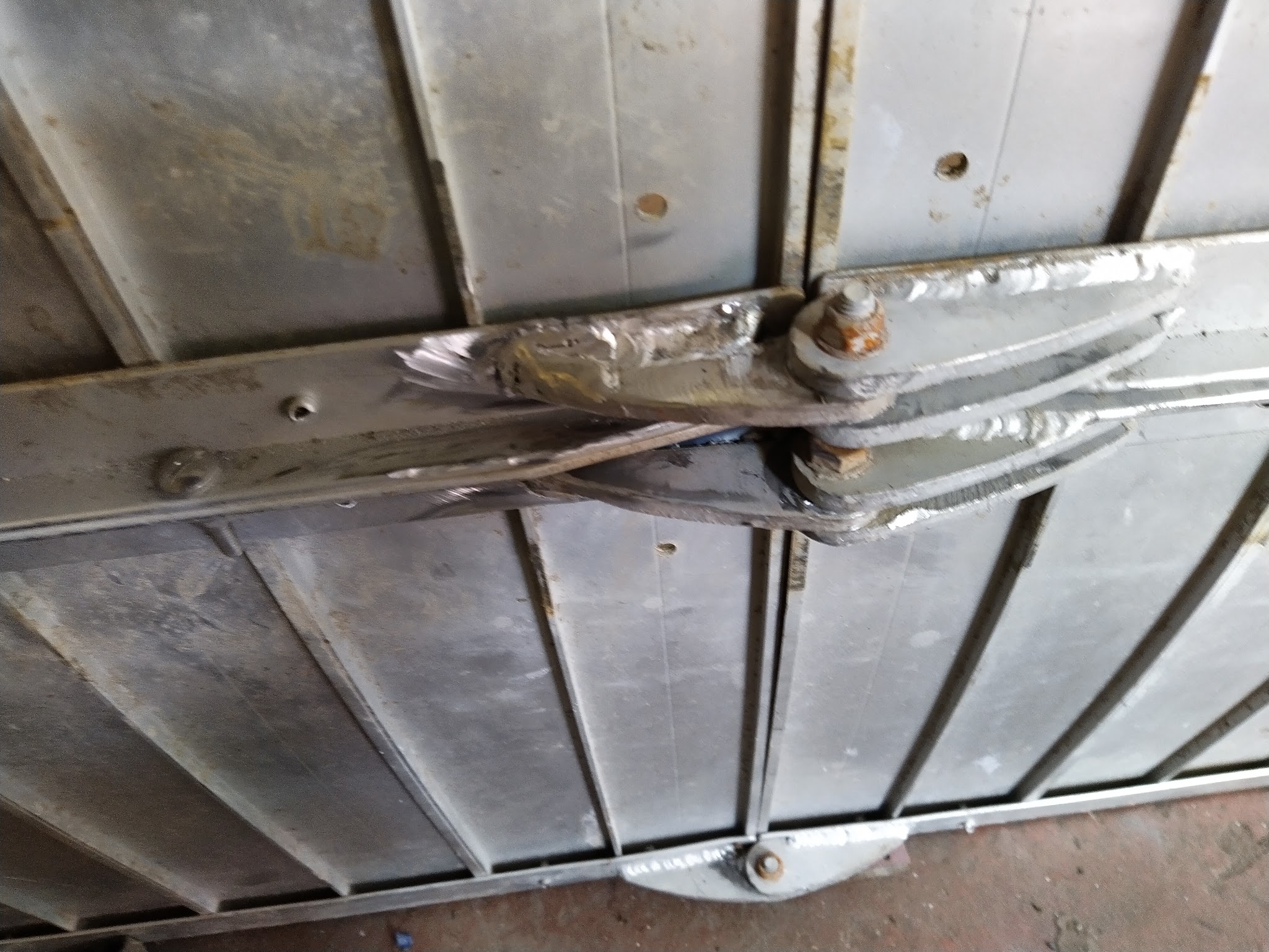 A welded repair on a metal panel hinge