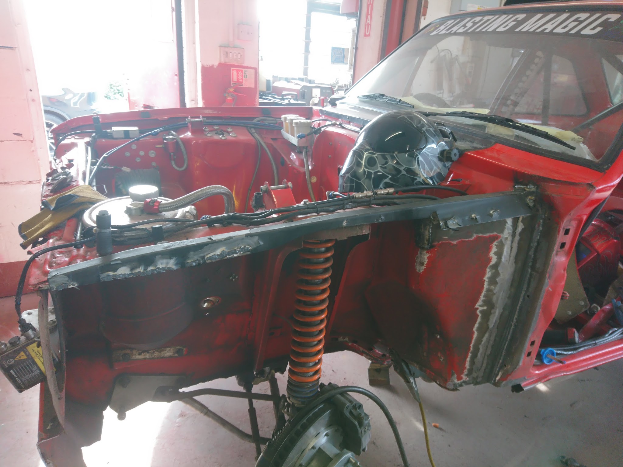 A red rally shell stripped back in the workshop during restoration