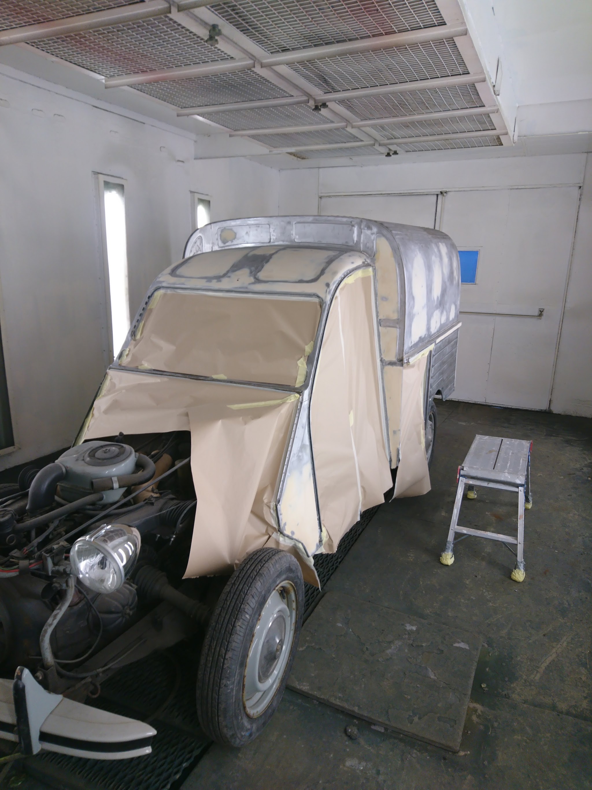 A classic Citroën masked up for paint in the spray booth