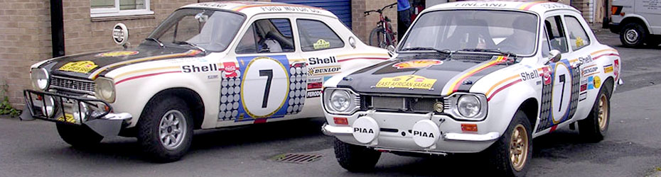 Two classic Ford Escort rally cars outside the workshop